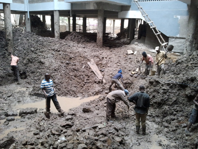 Waterlogged pool site being excavated and drained